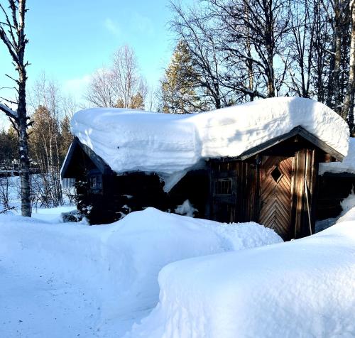 Cabaña cubierta de nieve con techo cubierto de nieve en Bäckstugan en Sälen