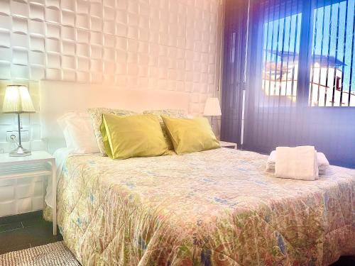 sypialnia z dużym łóżkiem z żółtymi poduszkami w obiekcie Estudio junto La Nogalera 1 w mieście Torremolinos