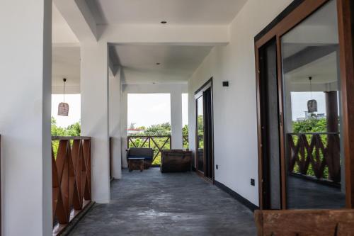 an internal corridor of a house with doors and a balcony at Baobab Bungalows in Jambiani