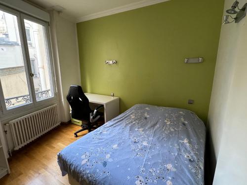 une chambre avec un lit, un bureau et une chaise dans l'établissement Grand appartement Michel-Ange, à Paris