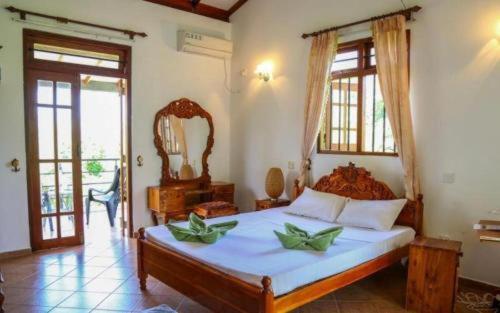 1 dormitorio con 1 cama grande y espejo en InVilla Hikkaduwa Sri Lanka en Hikkaduwa