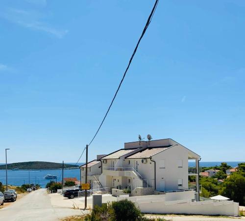 a white house on the side of a road at EllaVis Apartments in Vis