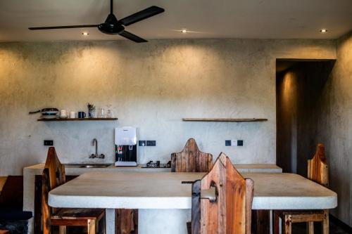 a kitchen with a table and some wooden chairs at Baobab Bungalows in Jambiani