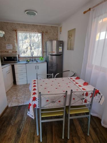 eine Küche mit einem Tisch und eine Küche mit einem Kühlschrank in der Unterkunft Cabañas Aquila D'Arroscia in Bahia Inglesa