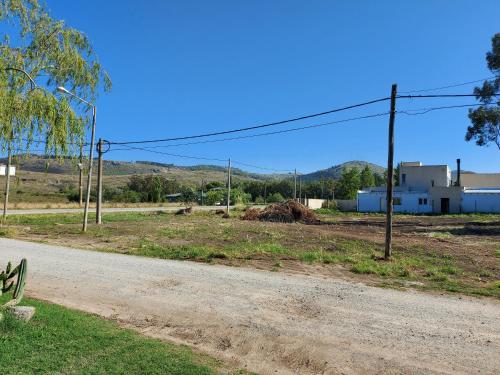 eine unbefestigte Straße neben einem Feld mit einem Gebäude in der Unterkunft Casa en El Paraíso Tandil in Tandil