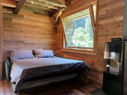 1 dormitorio con 1 cama en una cabaña de madera en Baita La Piana - Carona, en Carona