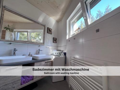 La salle de bains est pourvue de 2 lavabos et d'un miroir. dans l'établissement Apartments Viola Altenmarkt, à Altenmarkt im Pongau