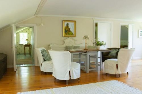 jadalnia ze stołem i białymi krzesłami w obiekcie Romantic villa on old Mansion w mieście Säffle
