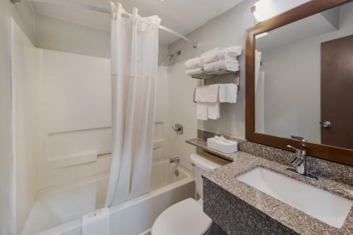 a bathroom with a sink and a toilet and a mirror at Quality Inn - Denton in Denton