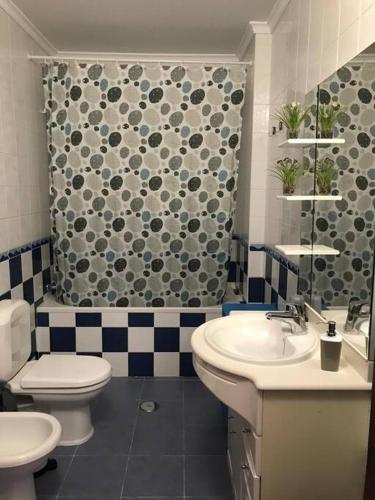 a bathroom with a toilet and a sink and a shower at The South Sunny House - A Casa a Sul in Olhão
