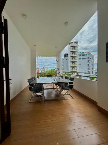 a dining room with a glass table and chairs on a balcony at Lộc Vừng Homestay in Phan Thiet