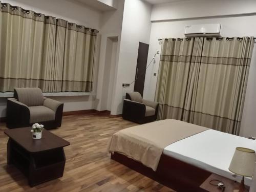 a hotel room with a bed and a couch and chairs at Thalangama Lakeview Lodge in Battaramulla