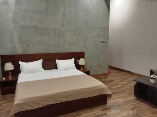 a bedroom with a large bed with two night stands at Thalangama Lakeview Lodge in Battaramulla