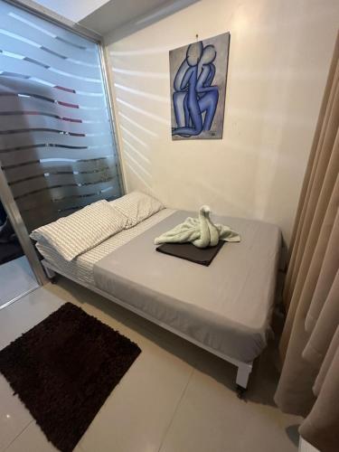 ein kleines Bett in einem Zimmer mit Fenster in der Unterkunft Staycation for you at Casa Amara near MOA in Manila
