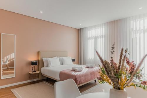 a bedroom with a bed and a table and chairs at Primeiro Quartel Apartments - 3 in Peso da Régua