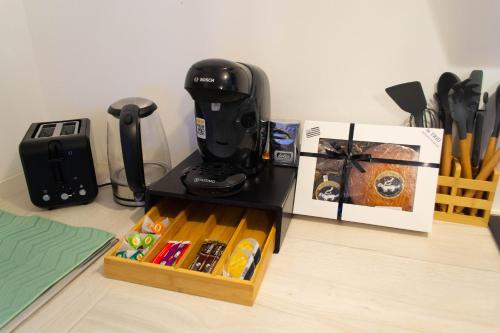 a coffee maker sitting on a table next to a box at Nid Paisible in Baud