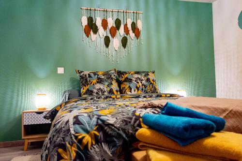 a bedroom with a bed with a green wall at Nid Paisible in Baud