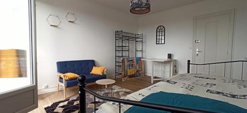 um quarto com uma cama, uma cadeira e uma mesa em Appartement cosy route des plages em Lorient