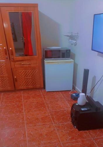 a kitchen with a microwave and a refrigerator at Welcome to Hilltop Villa in Dakar
