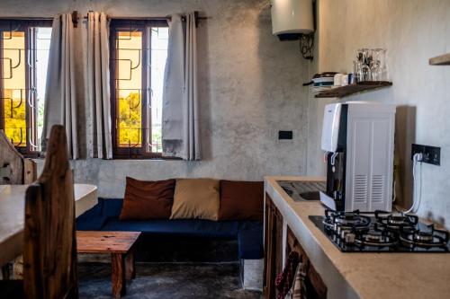 江比阿尼的住宿－Baobab Bungalows，客厅设有蓝色沙发,厨房设有