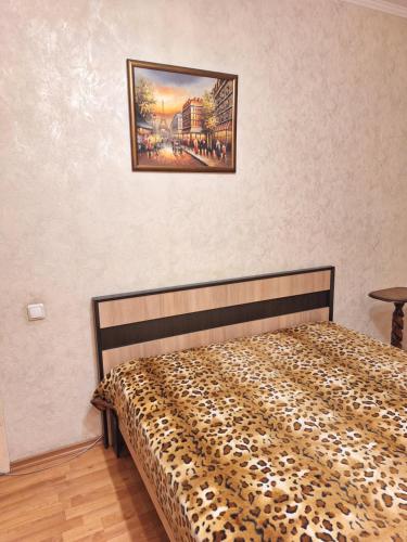a bed in a room with a picture on the wall at проспект Олександра Поля (пр. Кірова) in Dnipro