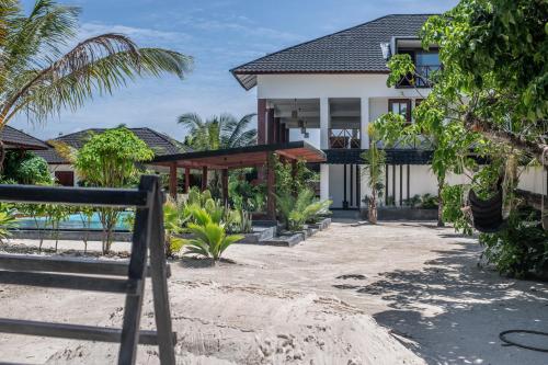 una casa en la playa con palmeras en Baobab Bungalows, en Jambiani