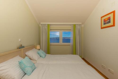 - une petite chambre avec 2 lits et une fenêtre dans l'établissement Nala Apartman 9, à Selce