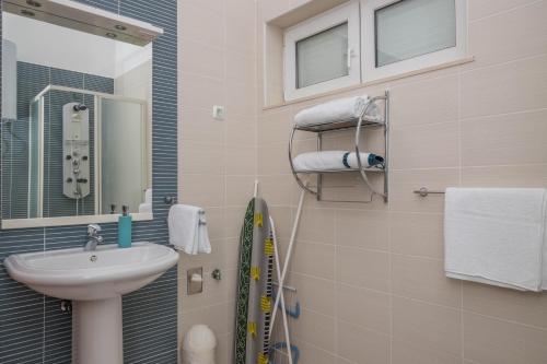 La petite salle de bains est pourvue d'un lavabo et d'un miroir. dans l'établissement Nala Apartman 9, à Selce