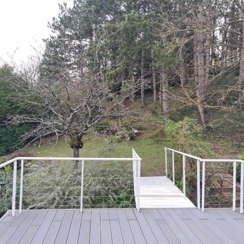 a wooden bridge with a tree on a hill at Chambre Marine in Château-Thierry