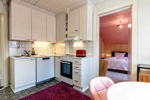 una cocina con armarios blancos y un aparato rojo en 4B Stay - Best Budget Boutique Boardinghouse, en Helsinki