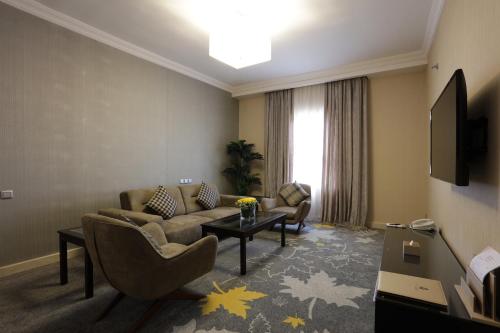 吉達的住宿－Warwick Hotel Jeddah，客厅配有沙发和桌子