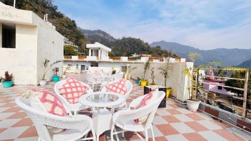 patio con mesa y sillas en el balcón en Perfect Stayz Hills en Rishīkesh