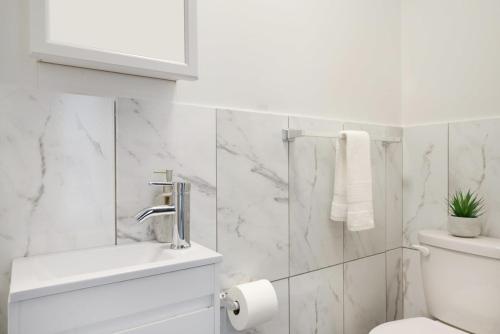 a white bathroom with a toilet and a sink at 153-5A Charming 2BR LES W D in New York