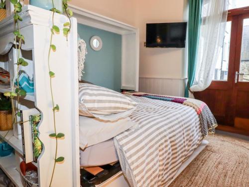 1 dormitorio con 1 cama con dosel blanco en Zawn Nook, en Falmouth