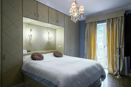 a bedroom with a large white bed with a chandelier at Le Petit Palais in Athens