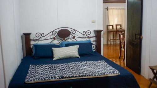 una camera con letto blu e cuscini blu di Neysa's Vacation House a Los Naranjos