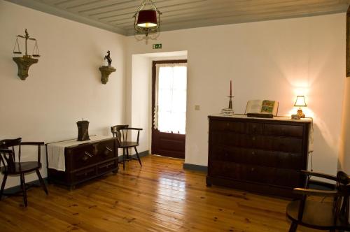a living room with a dresser and chairs and a window at Solar dos Caldeira e Bourbon in Zebras
