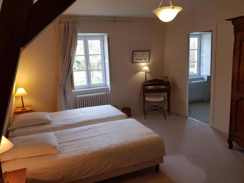 Huisseau-sur-CossonにあるLa Taille de Biouのベッドルーム1室(ベッド2台、デスク、窓2つ付)