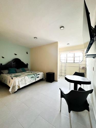 sypialnia z łóżkiem, stołem i krzesłami w obiekcie Apartamento pichones w mieście Comitán de Domínguez