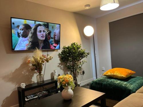 a living room with a flat screen tv on the wall at Hesed Home in Edinburgh