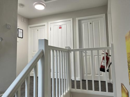 a hallway with two white doors and a staircase at Hesed Home in Edinburgh