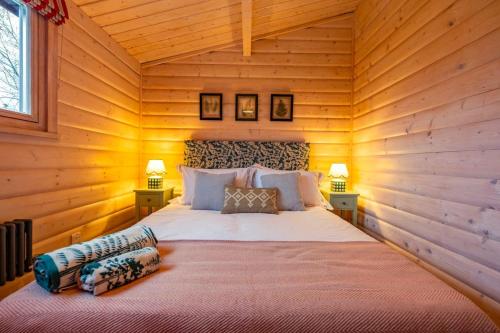 ein Schlafzimmer mit einem Bett in einem Blockhaus in der Unterkunft The Cabin in Marlow