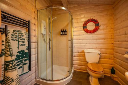 a bathroom with a toilet and a glass shower at The Cabin in Marlow