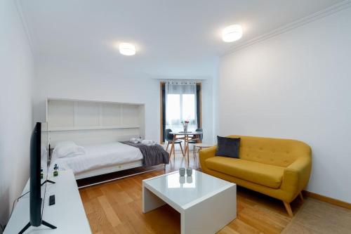 1 dormitorio con cama, sofá y TV en Estilo en calle Brasil by CABANA Rentals, en Vigo