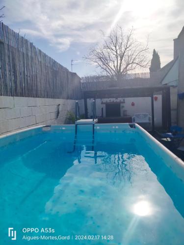 une grande piscine bleue dans une cour dans l'établissement maison entière avec piscine, à Aigues-Mortes