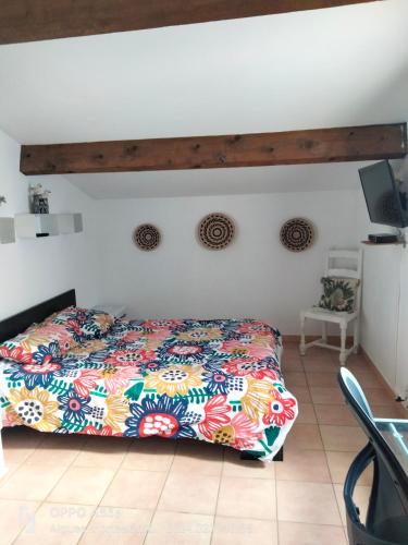 - une chambre avec un lit doté d'un couvre-lit coloré dans l'établissement maison entière avec piscine, à Aigues-Mortes