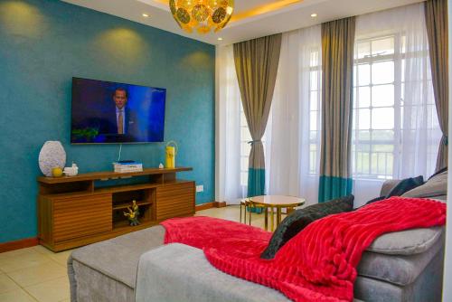a living room with a couch and a flat screen tv at House of DC- stylish 2 bedroom apartment in Kahawa