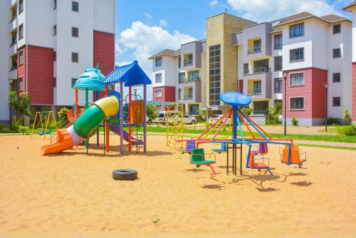 a playground in the sand in front of a building at House of DC- stylish 2 bedroom apartment in Kahawa
