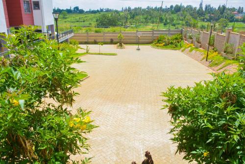 a brick walk way with trees and a building at House of DC- stylish 2 bedroom apartment in Kahawa