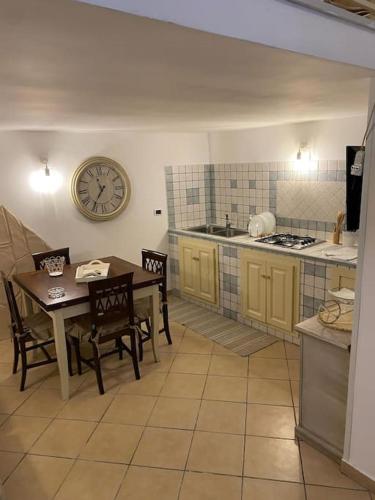 eine Küche mit einem Tisch und einer Uhr an der Wand in der Unterkunft Casa Catania Centro Il Bovio in Catania